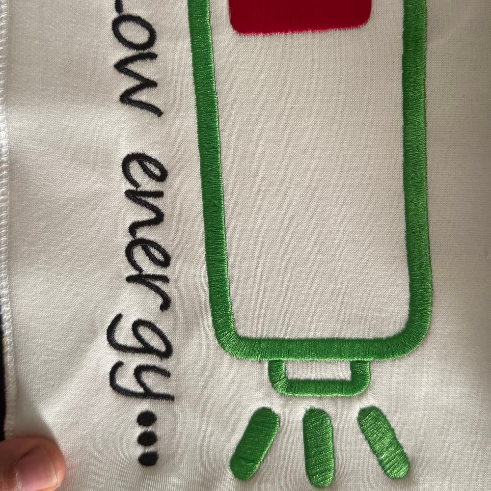 Besticktes Batterie-Motiv mit Schriftzug 'Low energy' auf Textil