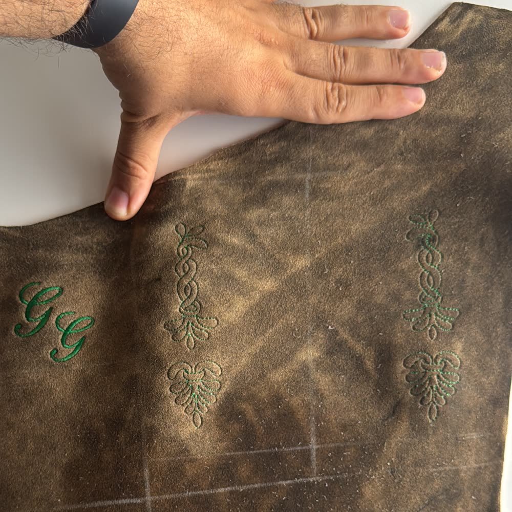 Monogramm 'GG' und florale Ornamente in Stickerei auf Leder