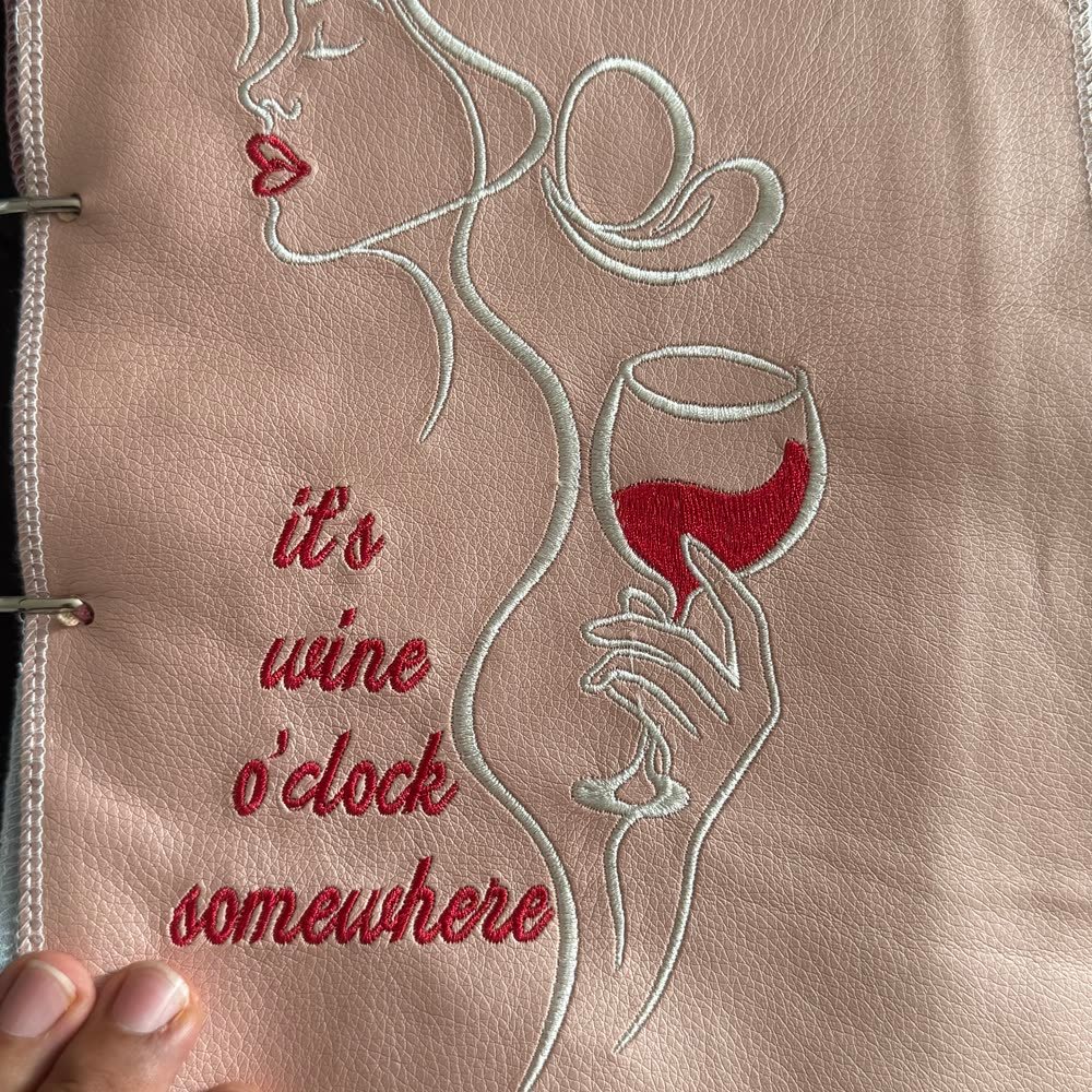 Bestickter Schriftzug 'it's wine o'clock somewhere' mit Silhouette auf Leder